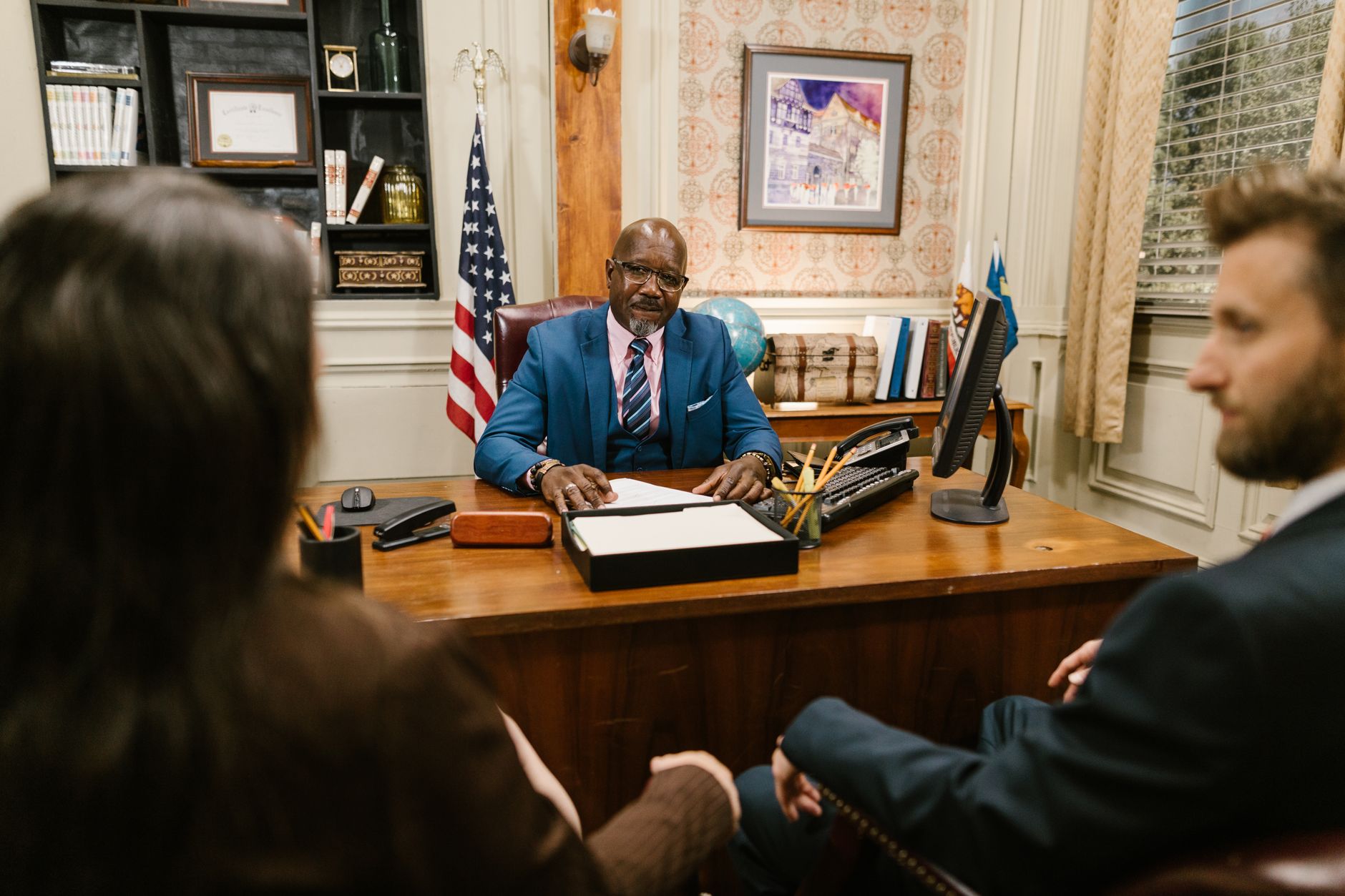 An attorney listening to two clients across his desk